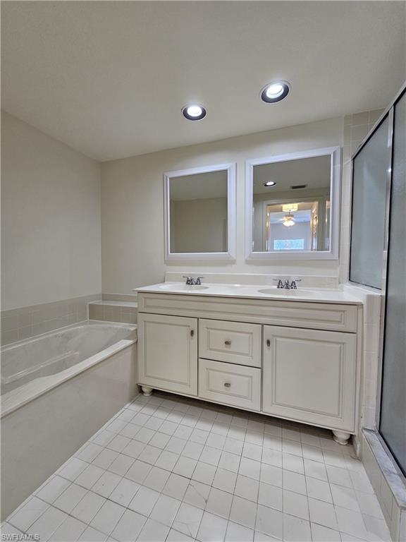 6025 Chardonnay Lane, Unit 102 Naples, FL 34119 - Photo 20 of 37 a spacious bathroom with a double vanity sink mirror and bathtub