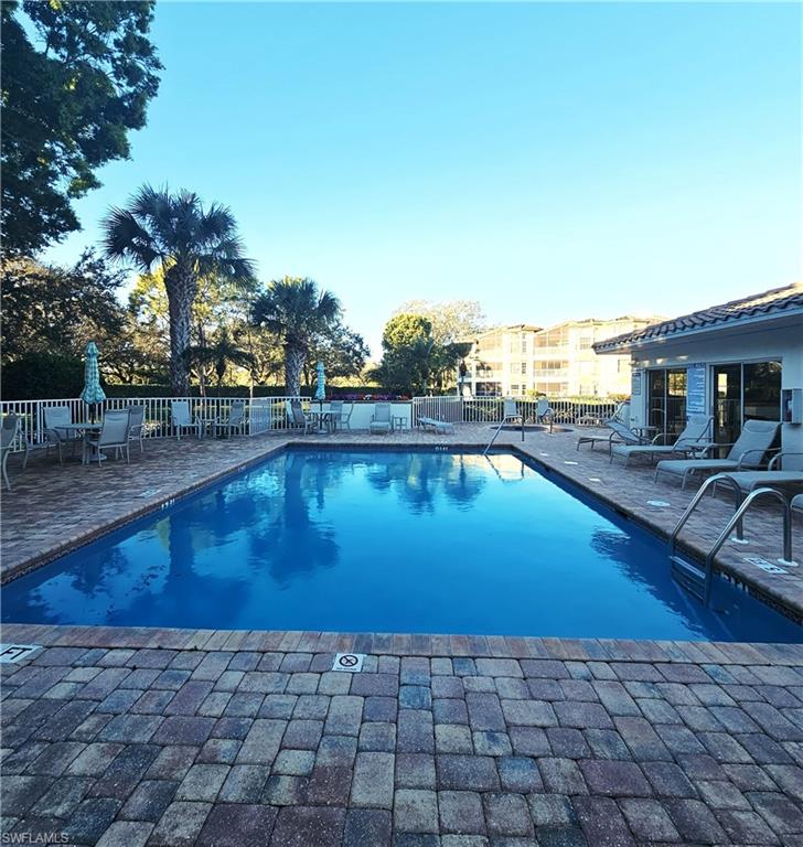 6025 Chardonnay Lane, Unit 102 Naples, FL 34119 - Photo 35 of 37 a view of a swimming pool with a lounge chair