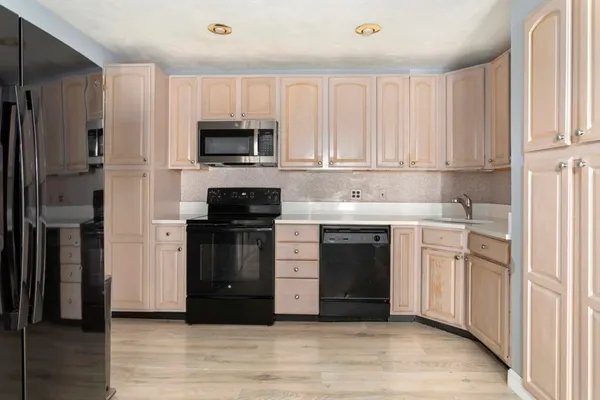 a kitchen with stainless steel appliances granite countertop a stove a sink and a microwave