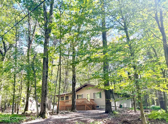 a front view of a house with a tree