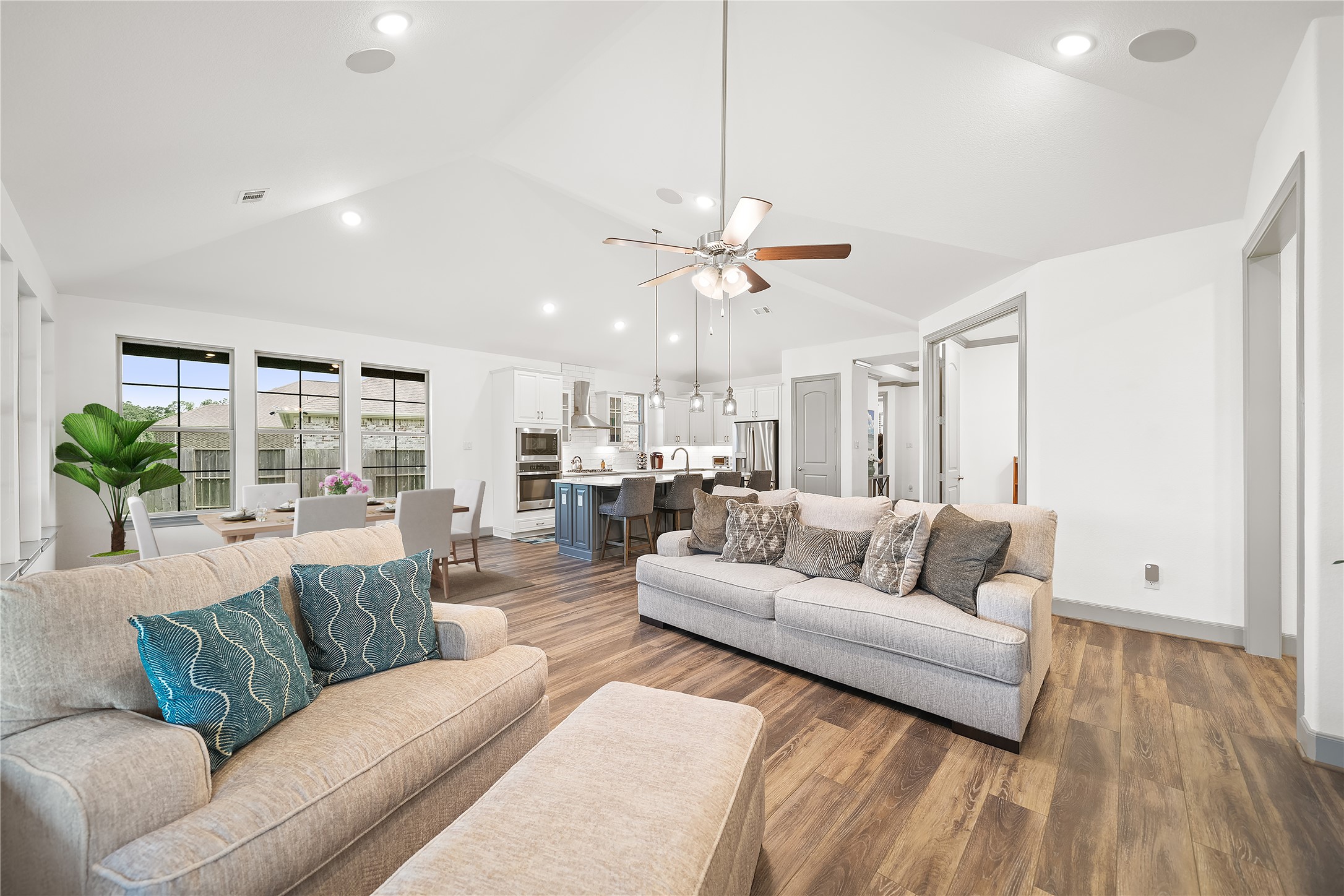 5739 Bobwhite Trail Manvel, TX 77578 - Photo 5 of 29 The open-concept design brings the living room, dining area, and kitchen together beneath soaring vaulted ceilings. Expansive windows fill the space with natural light and create an airy, welcoming atmosphere.