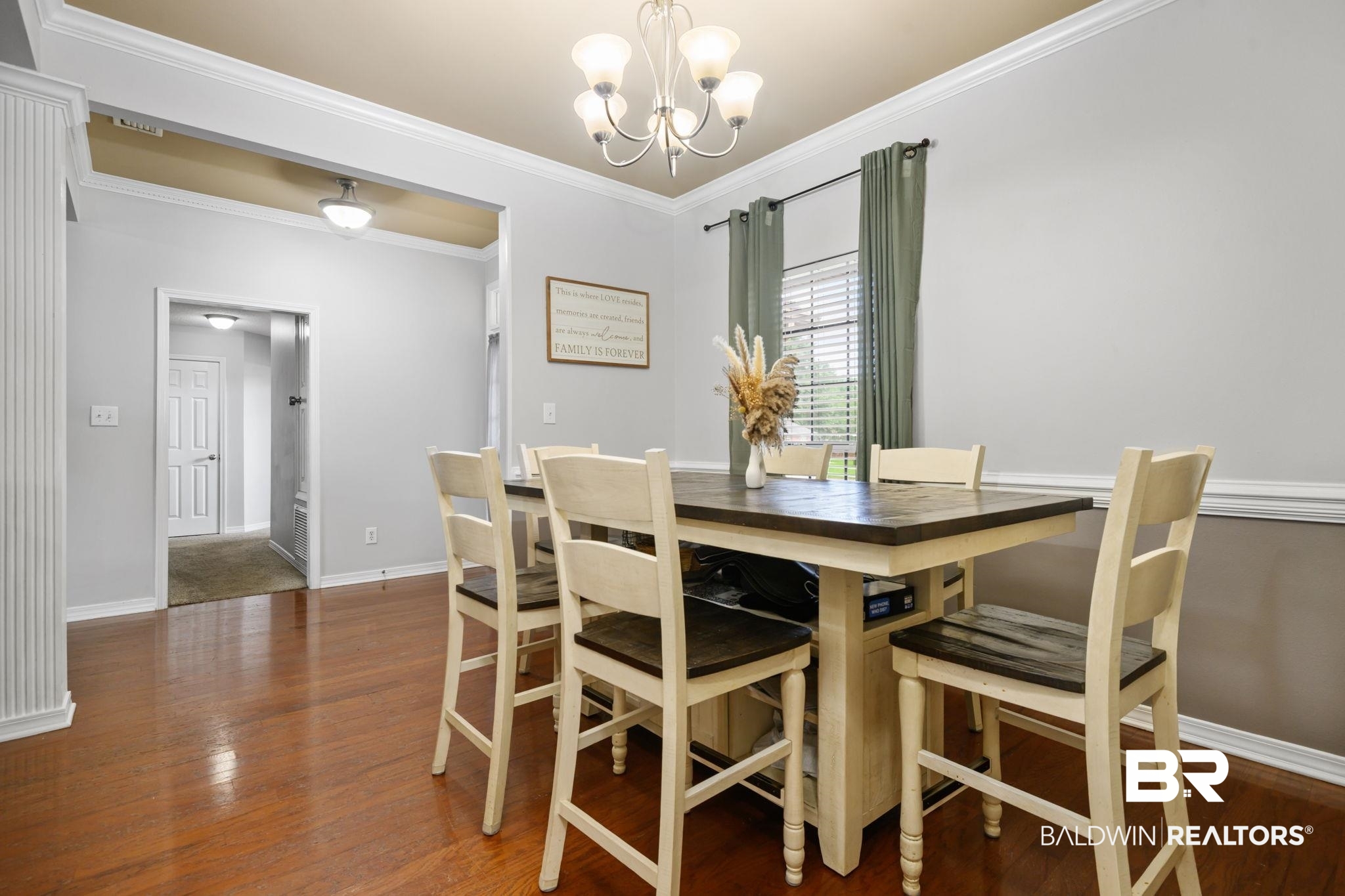 9422 Labrador Run South Mobile, AL 36695 - Photo 7 of 36 Dining area featuring wood-finish flooring, a contemporary chandelier, crown molding, a window with blinds, and a paneled accent column