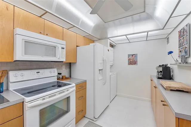a kitchen with stainless steel appliances a stove microwave and refrigerator