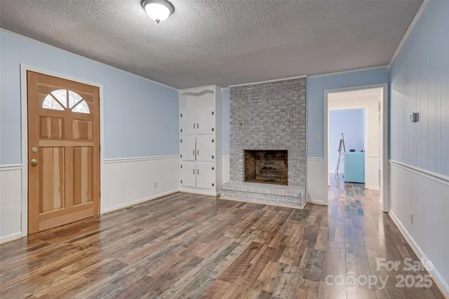 wooden floor fireplace and windows in an empty room