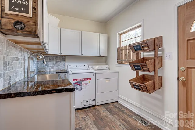 a view of a livingroom with wooden floor a ceiling fan and windows