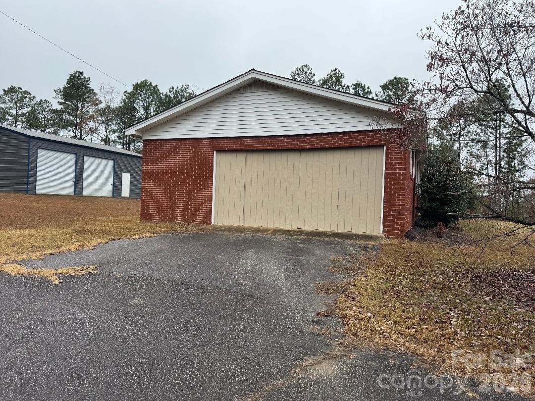 8684 Teals Mill Road Cheraw, SC 29520 - Photo 32 of 34 a front view of a house with a yard and garage