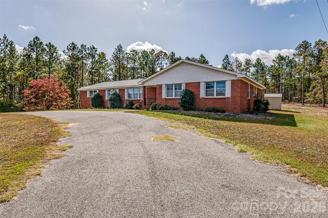 a front view of a house with a yard and trees