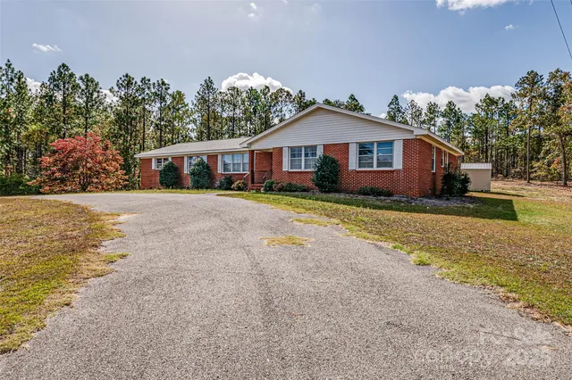 a front view of a house with a yard and trees