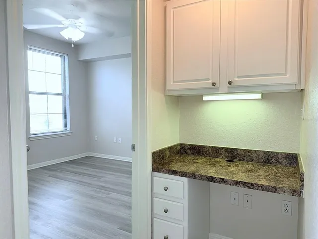 an empty room with granite countertop cabinets and entryway