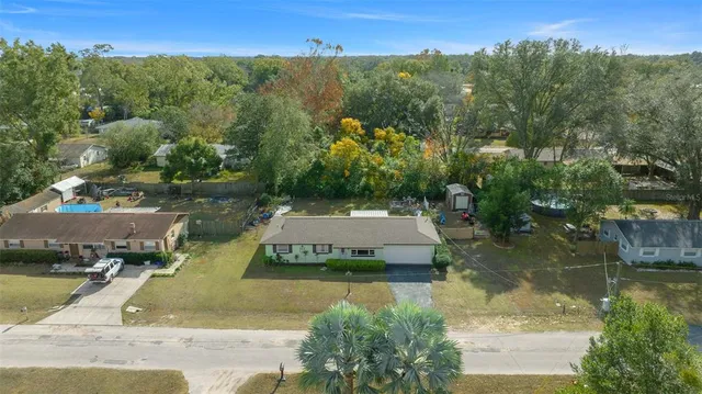 an aerial view of a house with swimming pool and a yard