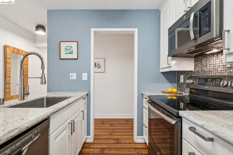 a kitchen with stainless steel appliances granite countertop a stove a sink and a microwave