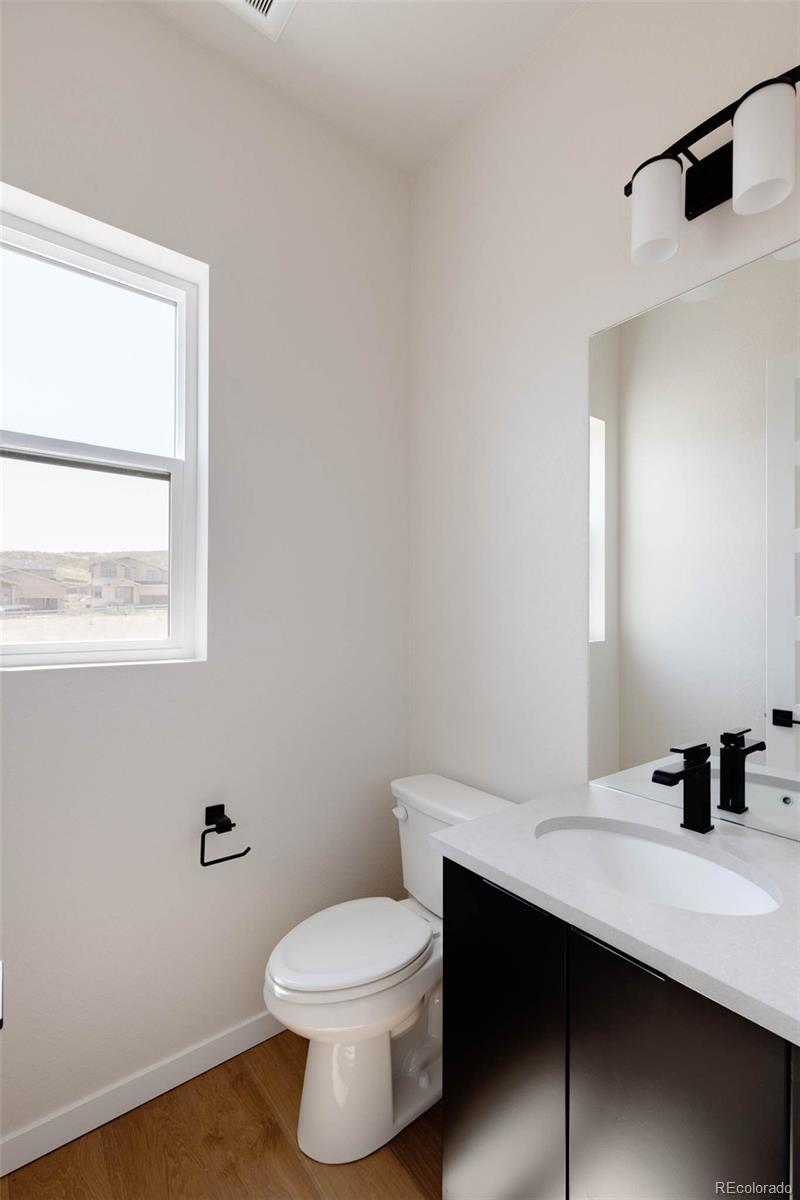 11468 Alla Breve Lone Tree, CO 80134 - Photo 20 of 34 a bathroom with a toilet a sink a vanity and mirror