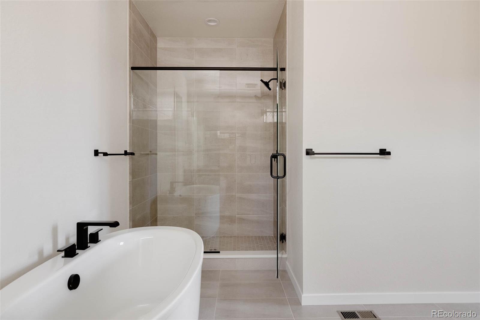 11468 Alla Breve Lone Tree, CO 80134 - Photo 24 of 34 a bathroom with a tub and a shower