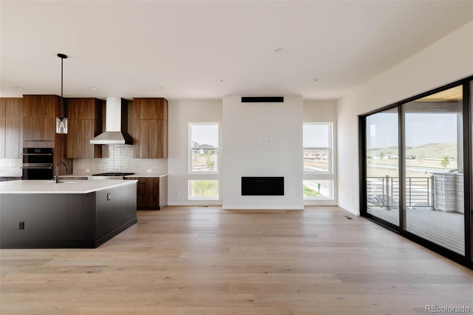 11468 Alla Breve Lone Tree, CO 80134 - Photo 9 of 34 a large kitchen with kitchen island granite countertop a stove a sink a refrigerator and a fireplace