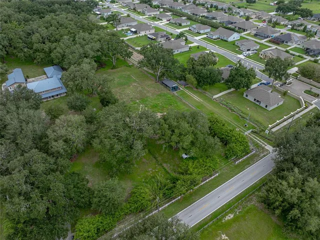 an aerial view of residential houses with outdoor space and street view