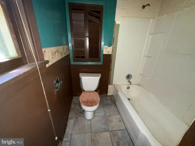 a bathroom with a toilet and a bathtub