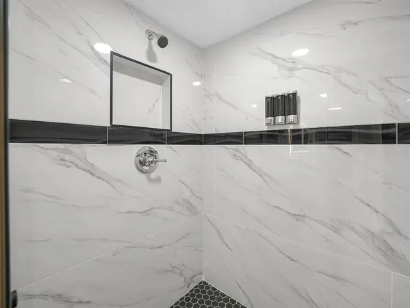 a bedroom with a bed and a black mirror