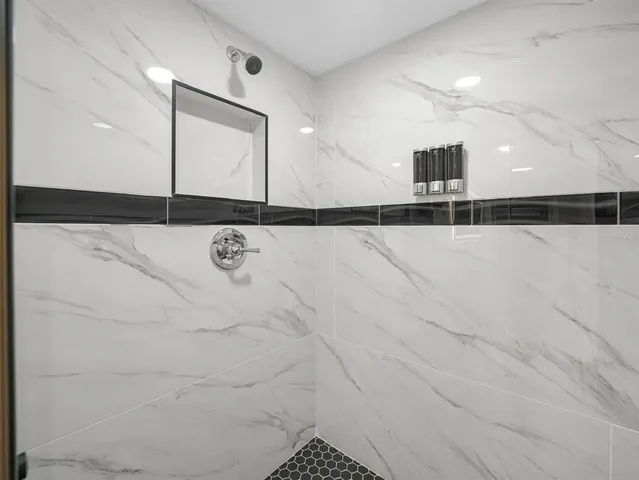 a bedroom with a bed and a black mirror