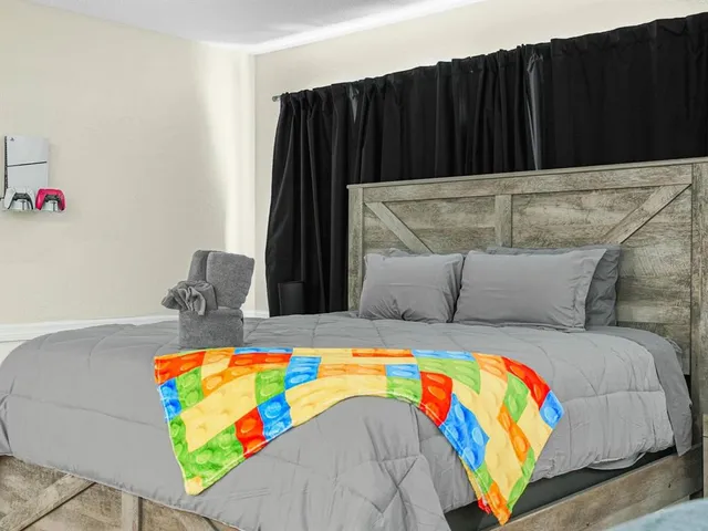 a spacious bedroom with a bed and a flat screen tv