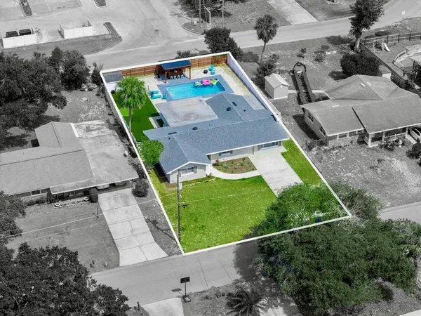 an aerial view of a house with a yard basket ball court and outdoor seating