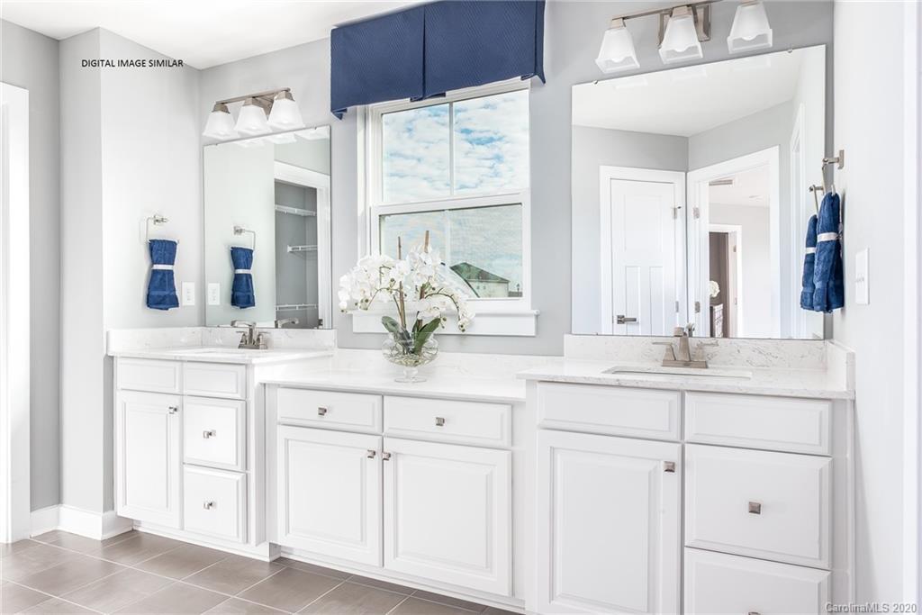 7126 Messina Road, Unit 134 Indian Land, SC 29707 - Photo 11 of 11 a bathroom with cabinets stainless steel appliances a sink and a large mirror