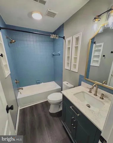 a view of an empty room with wooden floor fireplace and a window