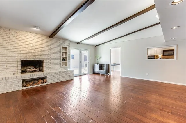 a view of a livingroom with furniture wooden floor and a fireplace