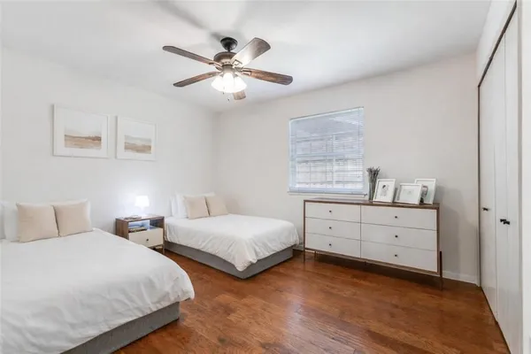 a bedroom with two beds and two window