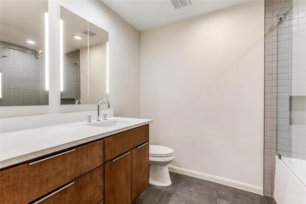 a bathroom with a granite countertop sink a toilet and a mirror