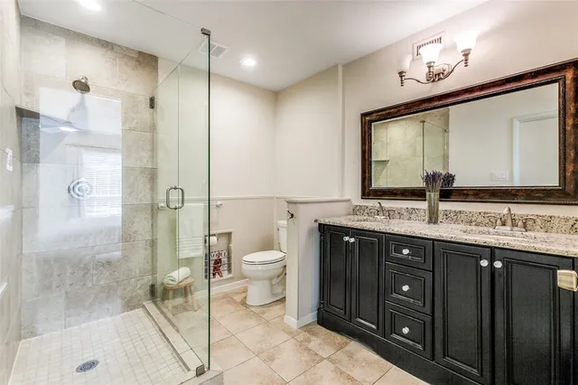 a bathroom with a granite countertop sink toilet and shower