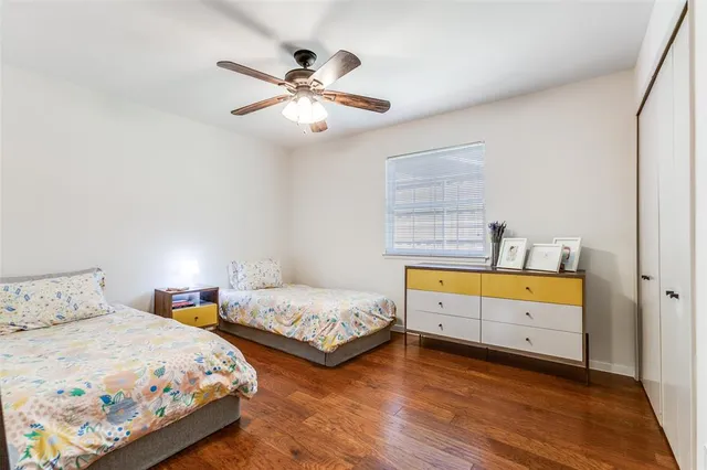 a bedroom with two beds and ceiling fan