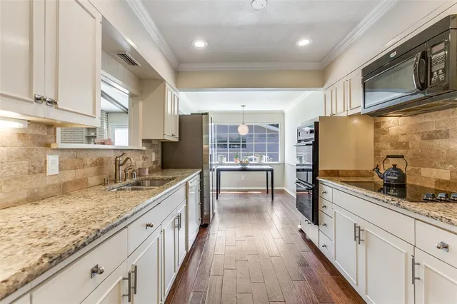 a large kitchen with stainless steel appliances granite countertop a lot of counter space and wooden floor