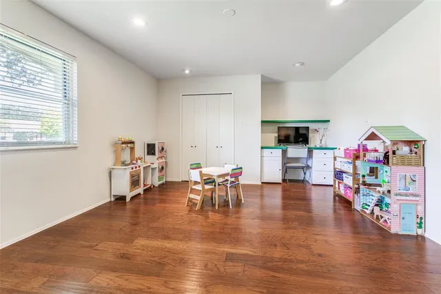 a playing room with furniture and a wooden floor