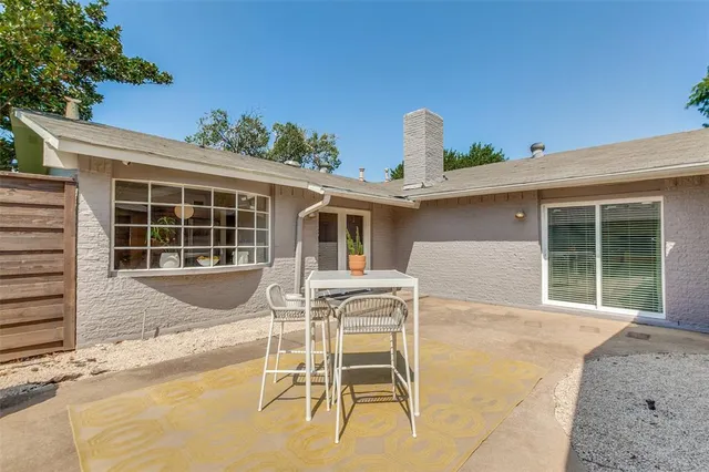 a view of a house with backyard and sitting area