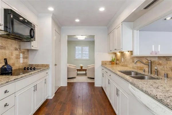 a kitchen with sink stove microwave and cabinets