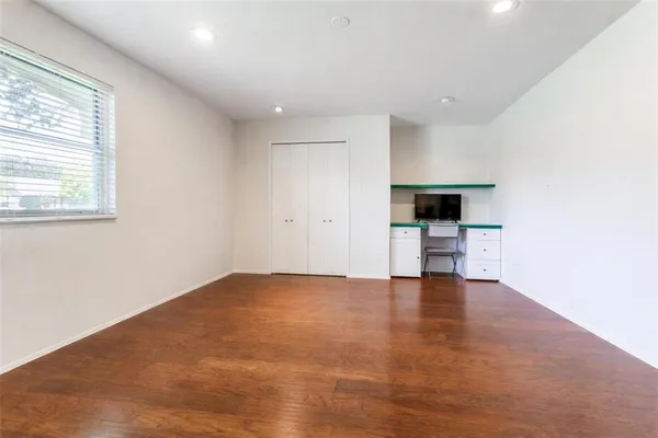 a view of empty room with kitchen and window