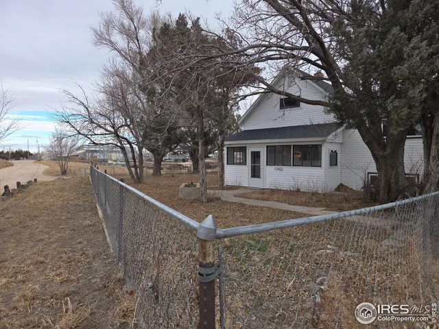 a white house that has a tree in front of it