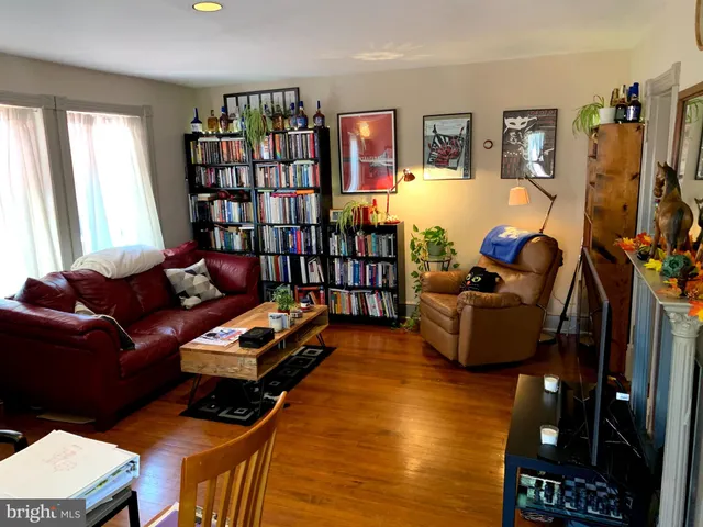 a living room with furniture a bookshelf and a flat screen tv