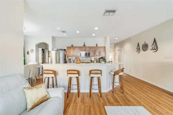 a living room with stainless steel appliances granite countertop furniture and wooden floor