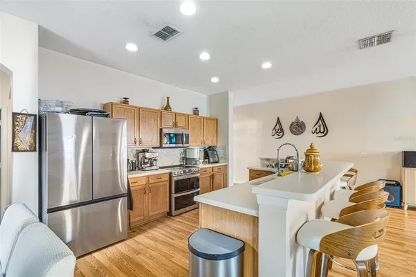 a kitchen with a refrigerator a stove a sink dishwasher and white cabinets with wooden floor