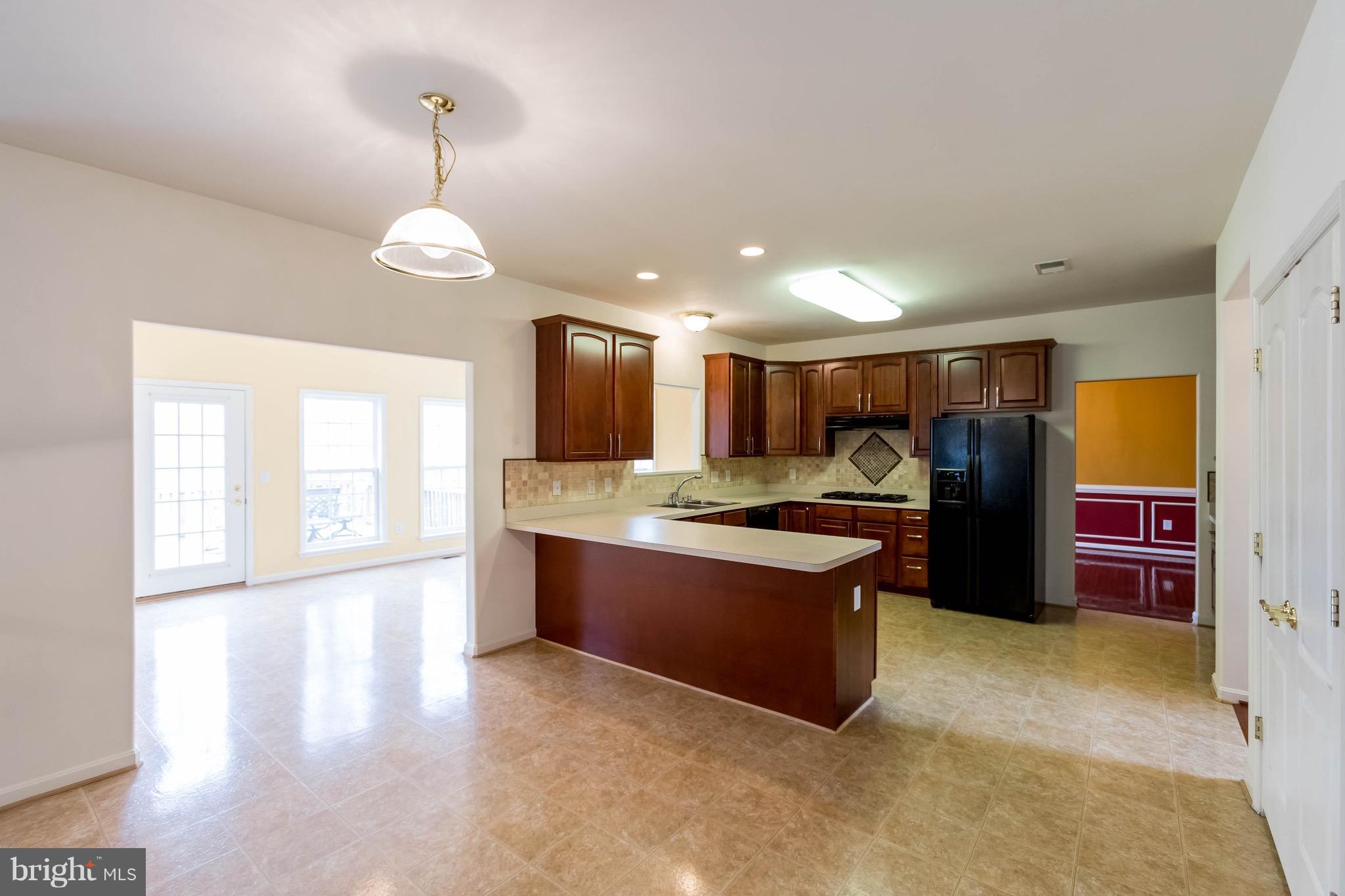 6732 North Stuart Road King George, VA 22485 - Photo 11 of 30 a large kitchen with stainless steel appliances granite countertop a stove and a refrigerator