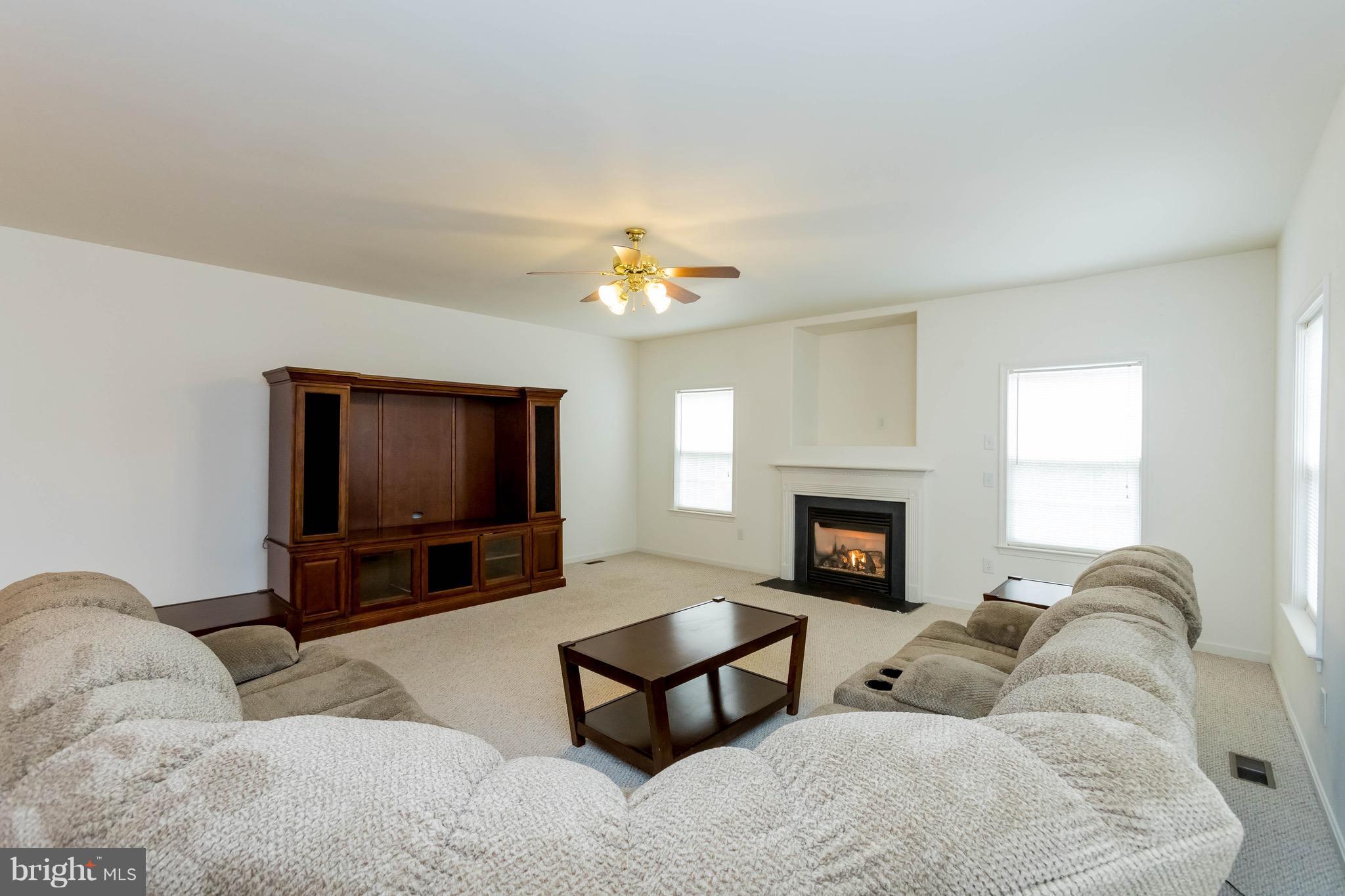 6732 North Stuart Road King George, VA 22485 - Photo 30 of 30 a living room with furniture a fireplace and a flat screen tv