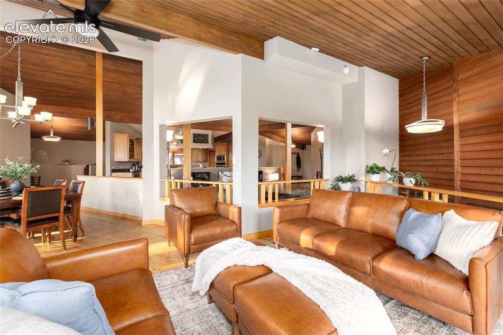 12730 Bridle Bit Road Colorado Springs, CO 80908 - Photo 11 of 50 Vaulted wood-paneled ceilings with exposed beams and a ceiling fan