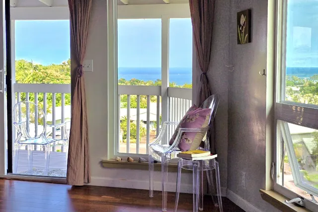 a view of a living room with a window and wooden floor
