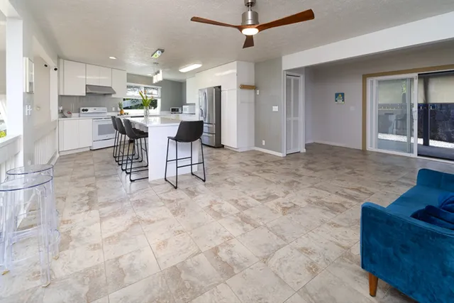 a view of a kitchen with kitchen island stainless steel appliances refrigerator stove a dining table and chairs