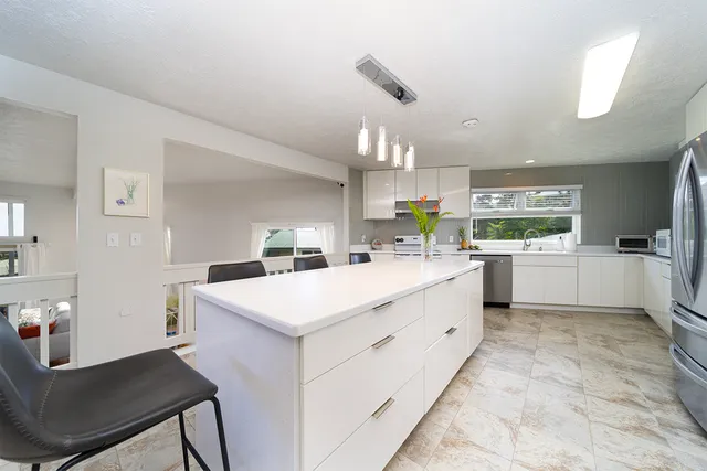 a kitchen with a sink a counter top space cabinets and stainless steel appliances