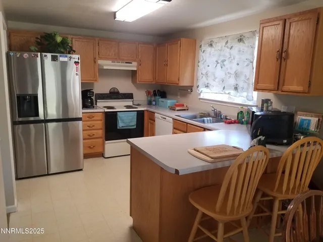 a kitchen with stainless steel appliances granite countertop a refrigerator sink and stove