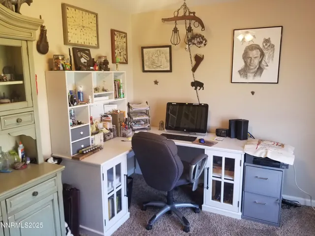 a view of a workspace with furniture and a window