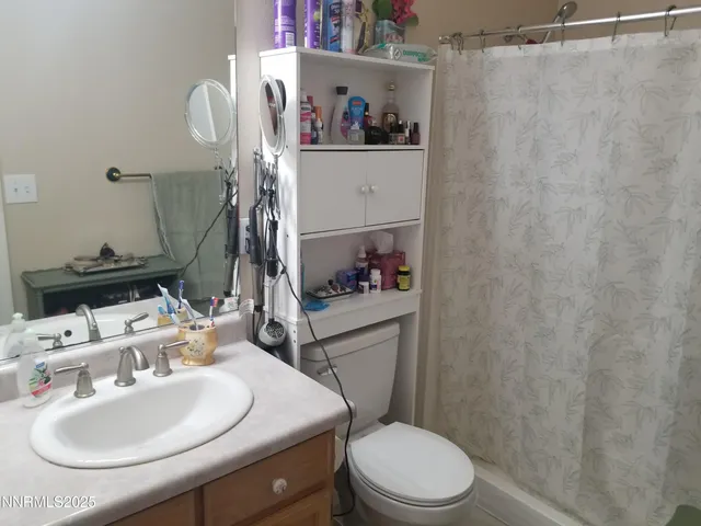 a bathroom with a sink a toilet and shower curtain