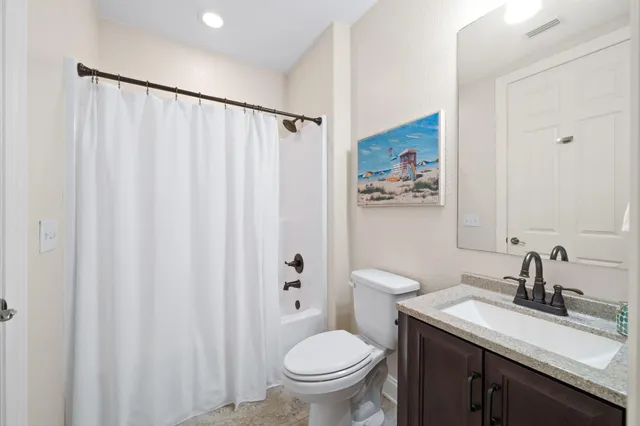 a bathroom with a granite countertop sink toilet and a mirror